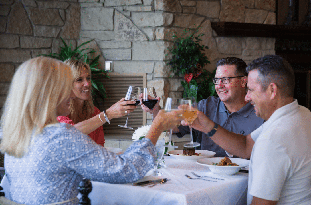 Group of adults toasting with wine glasses inside private dining room at Salina Country Club