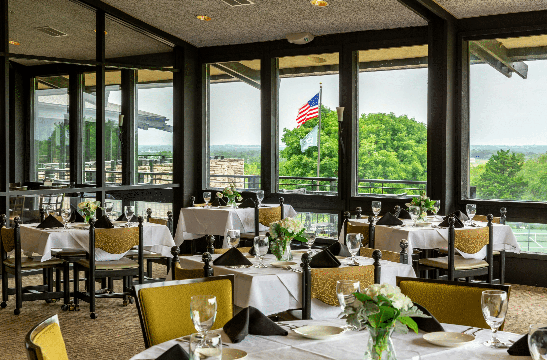 Indoor dining area at Salina Country Club with large windows overlooking outdoor property
