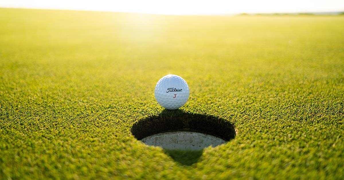 golf ball on a lip of hole on the green